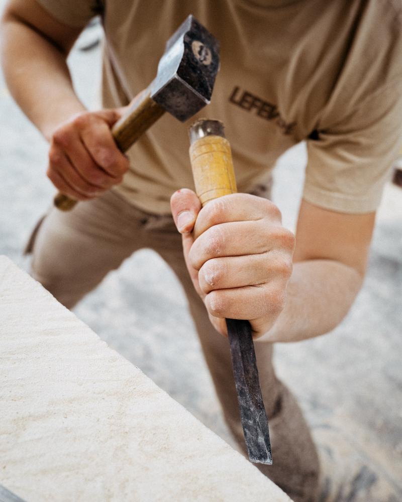 Stone mason at lefevre workshop Paris carving block of stone