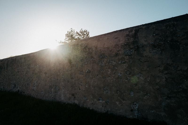 Sun rising behind dry stone wall around Calon Ségur, Saint-Estephe