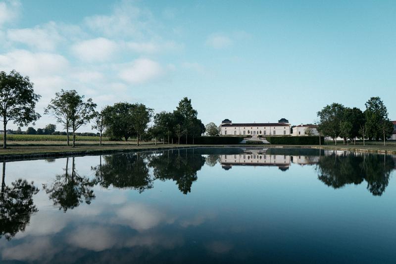 Landscape across the water of the chartreuse of Chateau Calon Ségur in morning light