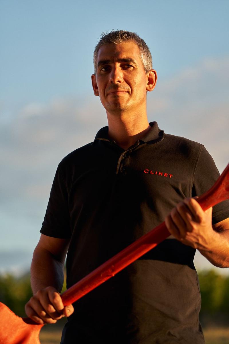 Portrait of Clinet vineyard worker holding red spade in both hands