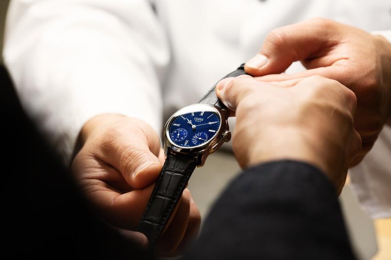 Czapek artisan passing blue quai des bergues watch to client