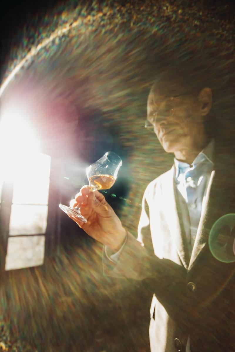 Delamain Cellar Master Charles Braastad inspecting Cognac eaux-de-vie in the sunlight entering through the window