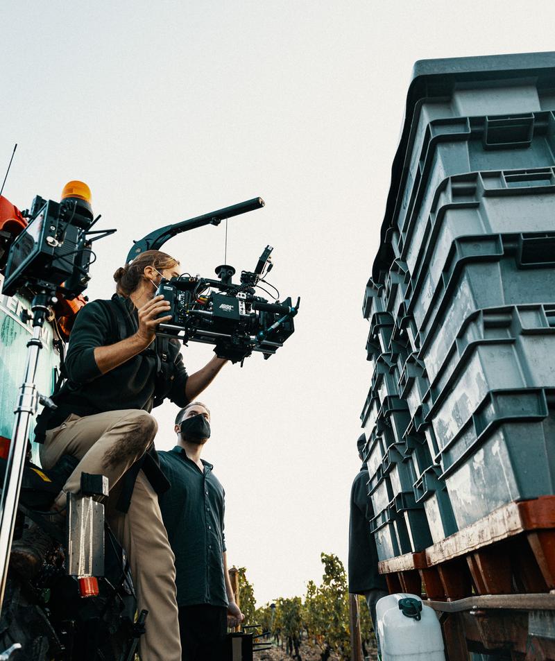 Cameraman sat on tractor with Arri Alexa mini filming wine harvest