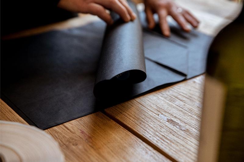 Close up of hands rolling bottle of wine in tissue paper