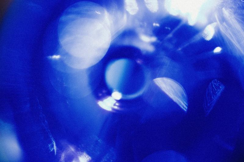 Artistic light reflections seen through blue bottle of Gin 44