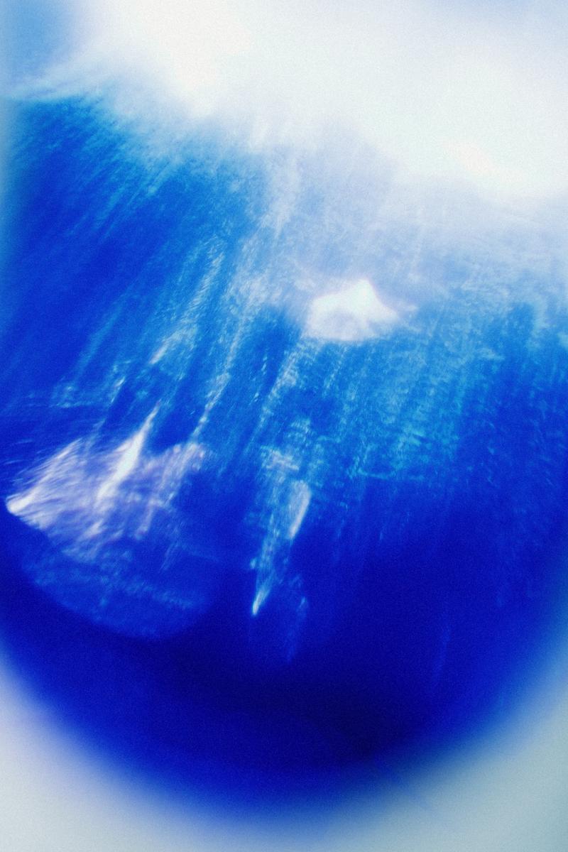 Artistic patterns of light shining through blue bottle of Gin 44