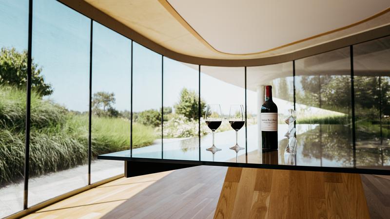 Tasting room at Château Haut-Bailly with bottle and two red wine glasses sitting on table
