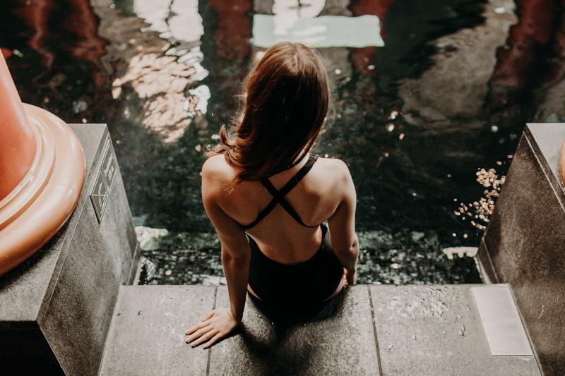 Girl from behind sat by poolside at Le Grand Hotel spa