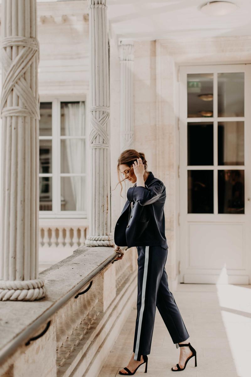 Girl standing on walkway leaning over barrier touching hair