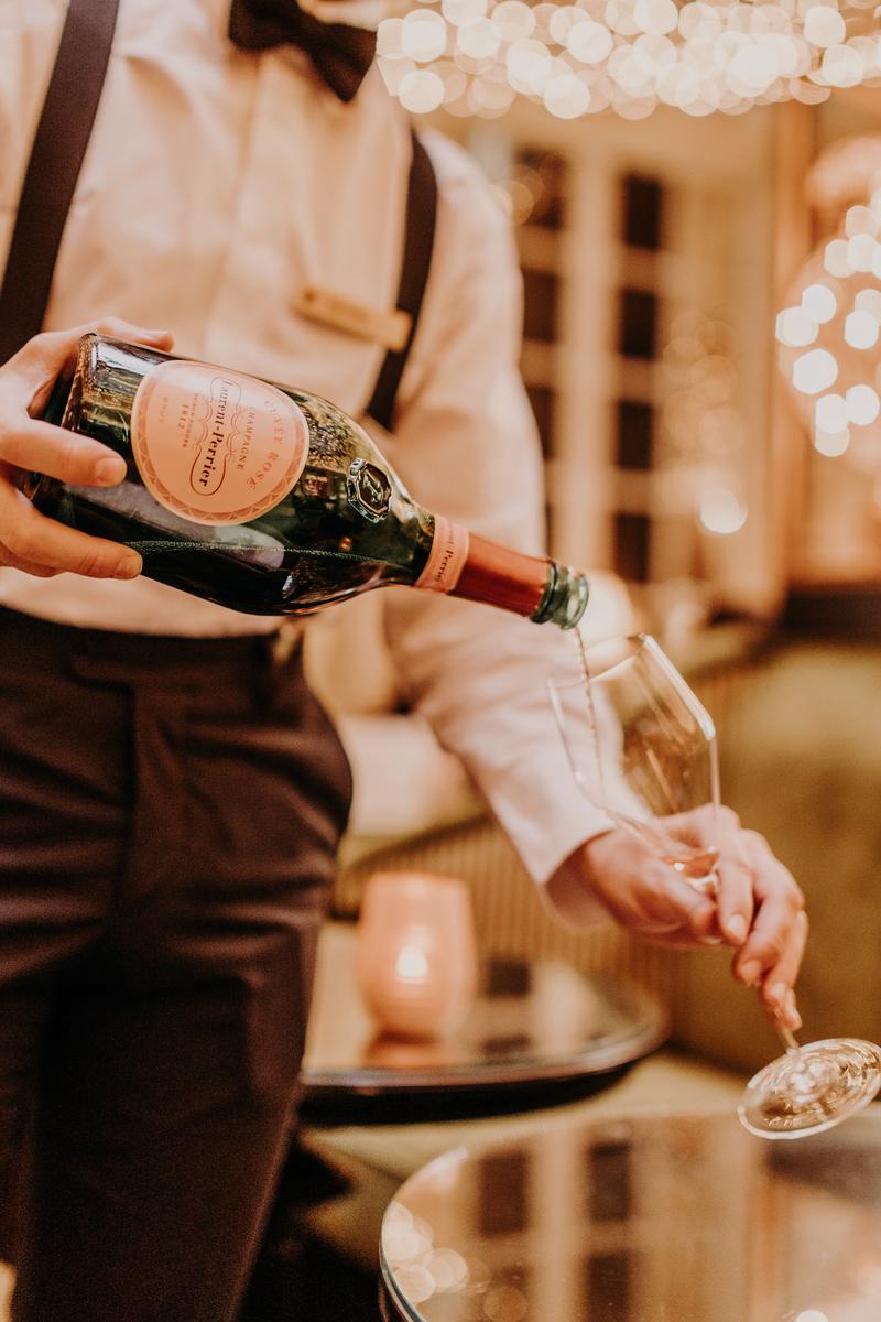 Close up of man pouring bottle of Laurent Perrier rosé
