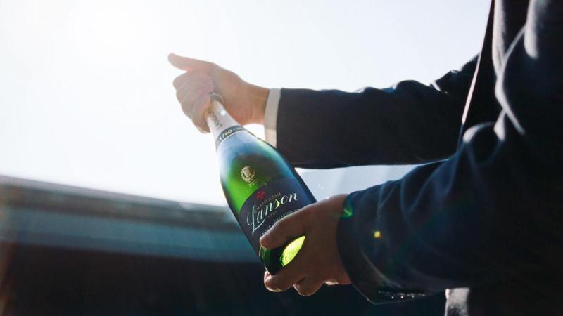 Still from Lanson x Wimbledon campaign, bottle held up to the sky