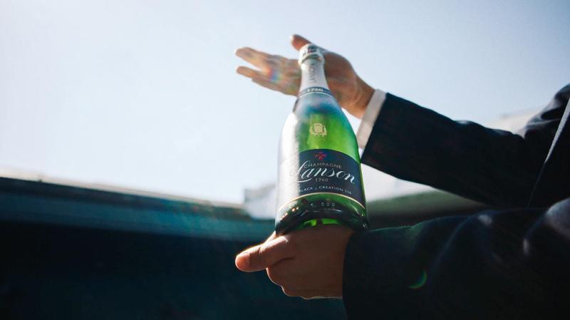 Bottle of Champagne Lanson held up to the sky at Wimbledon Center Court