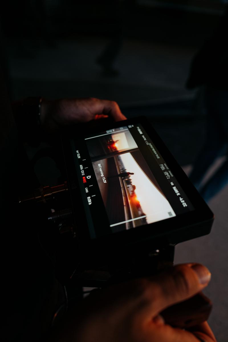 Behind the scenes through video monitor of Jonathan Maltus at sunset