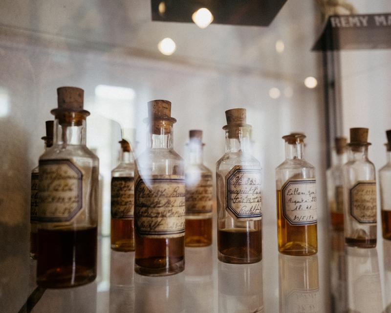 Old flasks of cognac eaux-de-vie in display cabinet