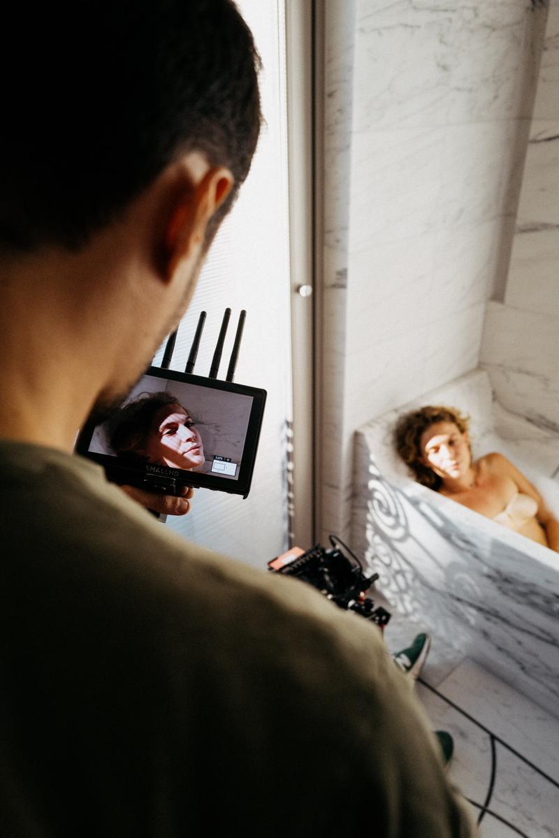 View through video monitor of girl lying in marble bath at Lutetia