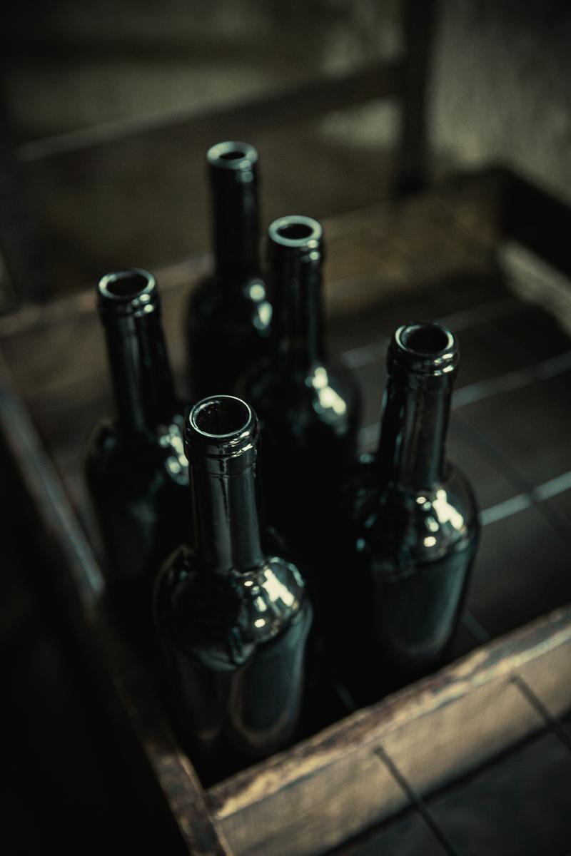 Empty wine bottles sitting in crate waiting to be filled