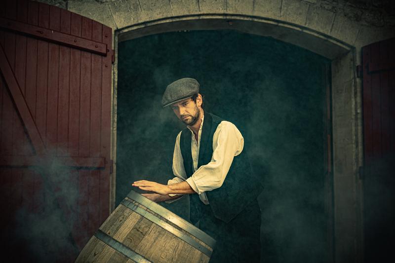 Winemaker in the style of Peaky Blinders rolling a wine barrel through doorway