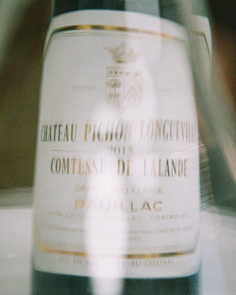 Distorted view through wine carafe of a bottle of Chateau Pichon Comtesse 2015