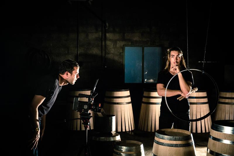 Backstage of Alexis Willis filming percussionist surrounded by wine barrels